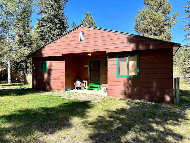 rear view of house featuring a yard