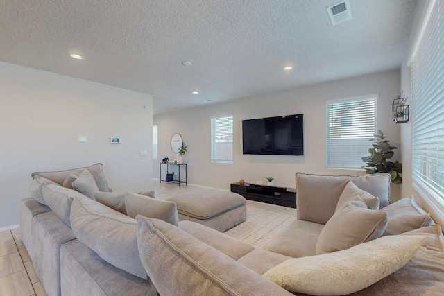 tiled living room featuring a textured ceiling