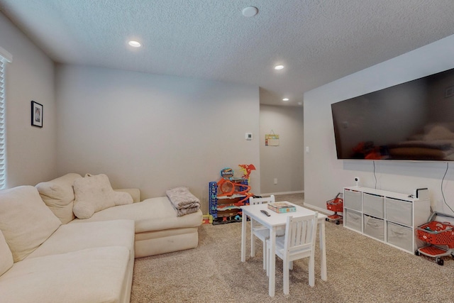 recreation room with a textured ceiling and light carpet