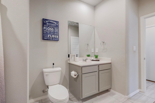 bathroom featuring vanity, tile patterned flooring, and toilet