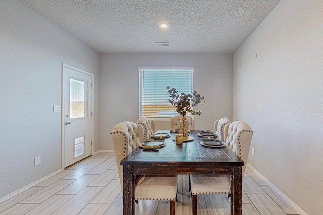 dining area featuring a wealth of natural light and a textured ceiling