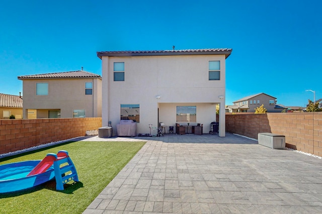 rear view of house with a yard and a patio