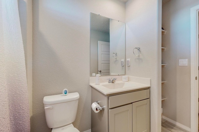 bathroom featuring vanity, toilet, and hardwood / wood-style flooring