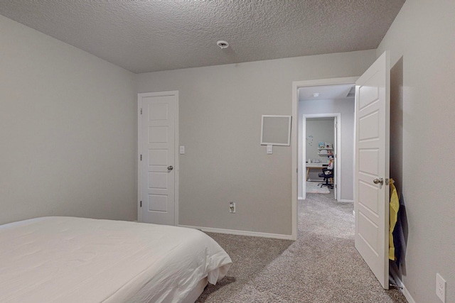 bedroom featuring a textured ceiling and light colored carpet