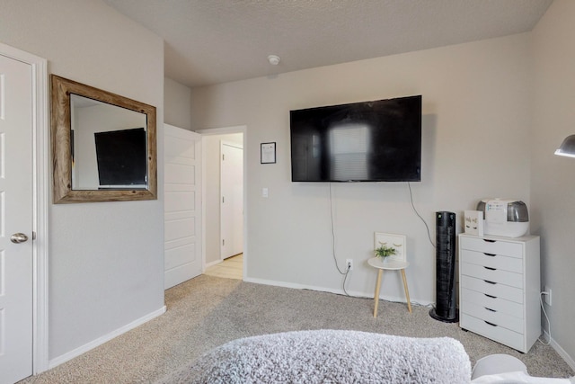 bedroom with light colored carpet and a textured ceiling