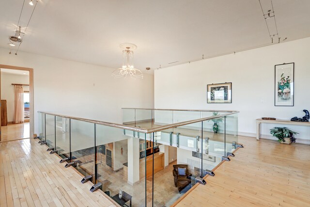 stairway with a chandelier and hardwood / wood-style flooring