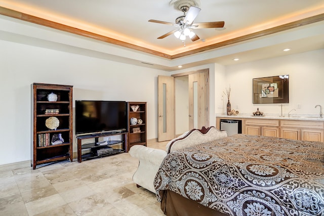 bedroom featuring ceiling fan, wet bar, and a tray ceiling