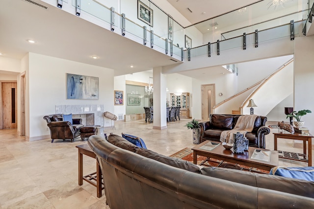 living room featuring a high ceiling and a high end fireplace