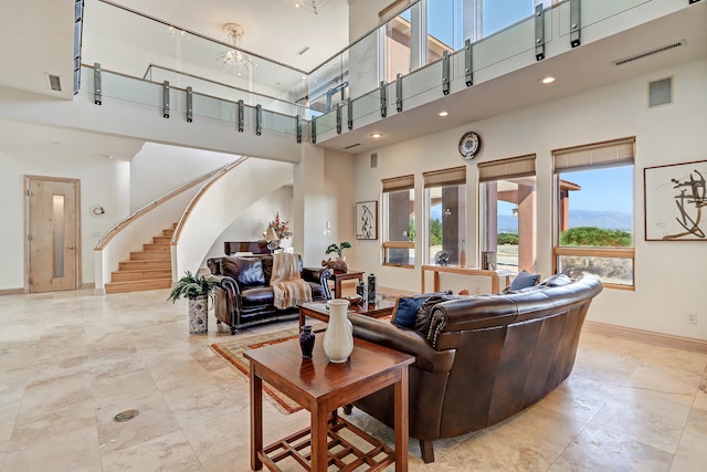 living room featuring an inviting chandelier and a towering ceiling