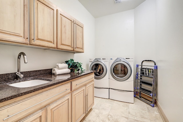 laundry room with cabinets, independent washer and dryer, and sink