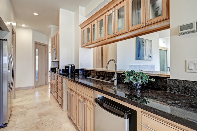 kitchen with dark stone countertops, appliances with stainless steel finishes, and sink