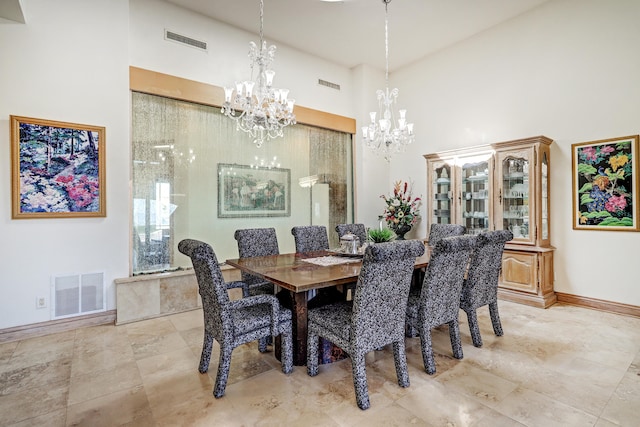 dining area featuring a notable chandelier, a towering ceiling, and a healthy amount of sunlight