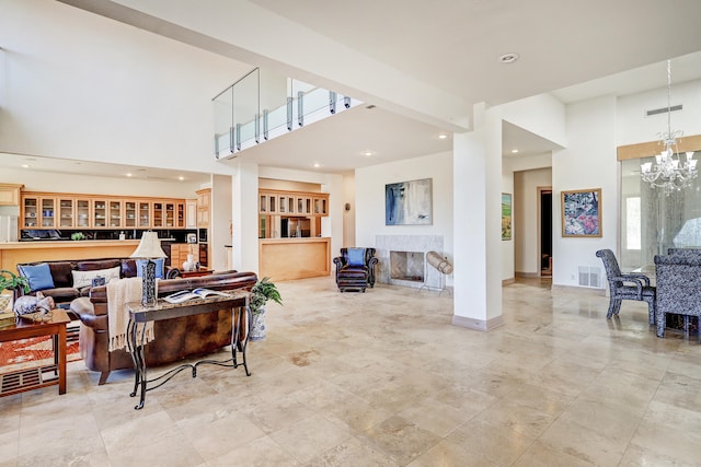 living room with a notable chandelier, built in features, and a high ceiling