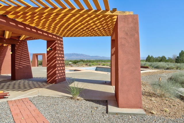 view of patio featuring a pergola and a mountain view