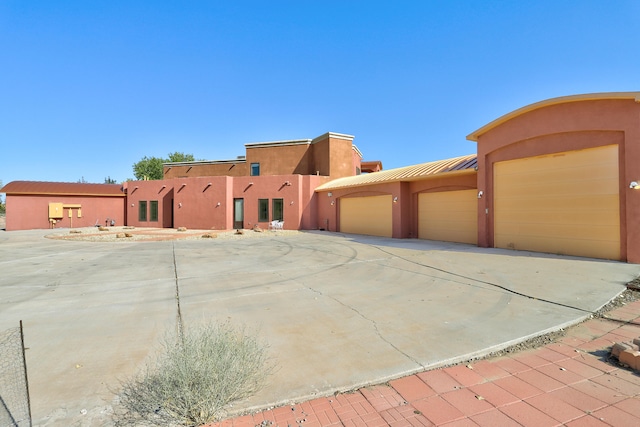 pueblo revival-style home featuring a garage