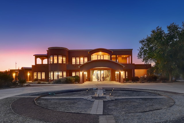 back house at dusk with a balcony