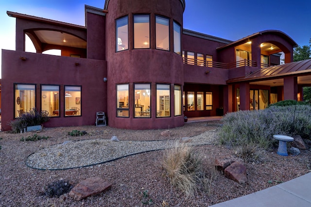 view of back house at dusk