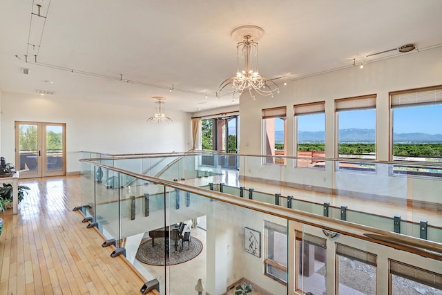 hall with a notable chandelier, light wood-type flooring, and a mountain view