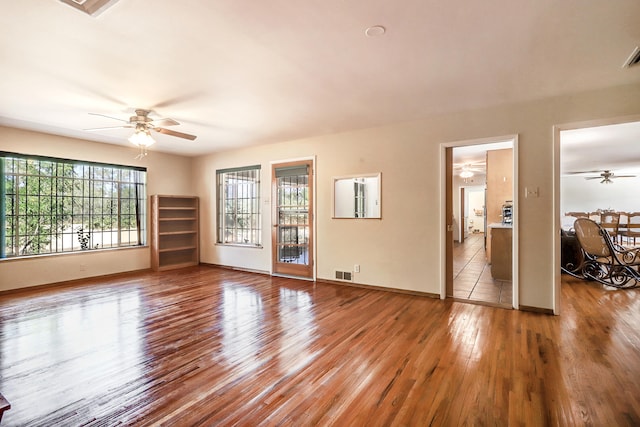 unfurnished living room featuring ceiling fan and hardwood / wood-style floors