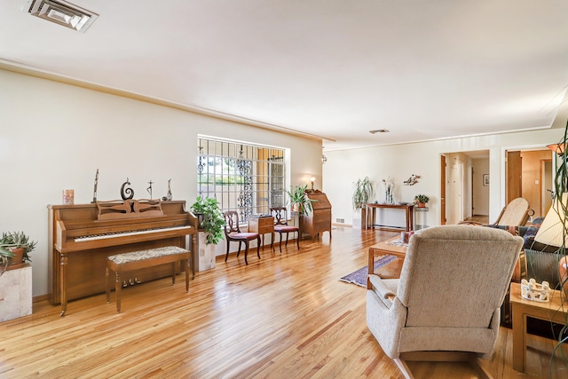 living room featuring light wood-type flooring and ornamental molding