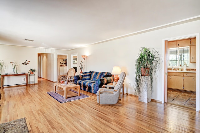 living room featuring crown molding and light hardwood / wood-style floors