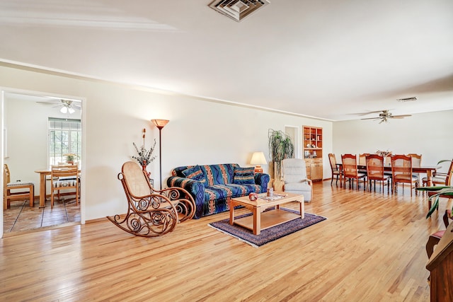 living room with ceiling fan and light hardwood / wood-style flooring