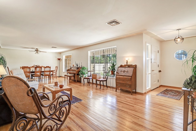 living room with light hardwood / wood-style flooring and ceiling fan