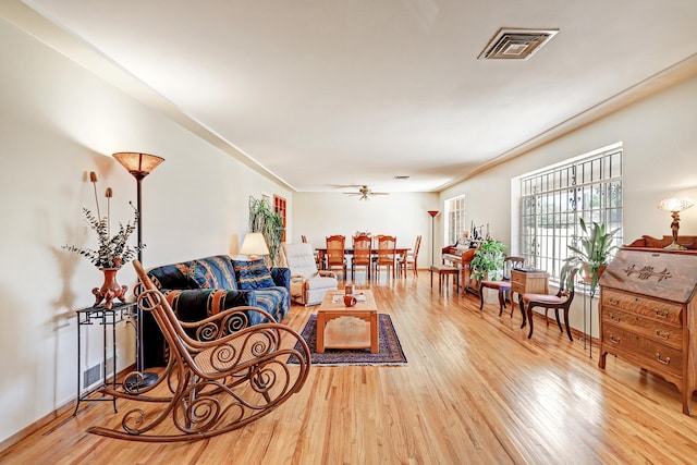 living room featuring hardwood / wood-style floors and ceiling fan