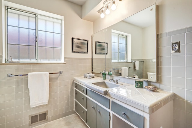 bathroom with tile walls, vanity, and tile patterned floors