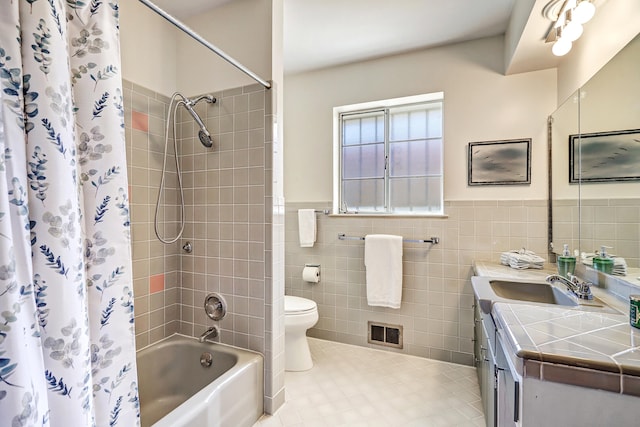 full bathroom with tile walls, shower / tub combo, vanity, tile patterned flooring, and toilet