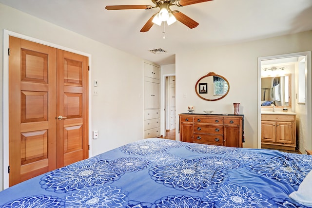 bedroom with ceiling fan, sink, and ensuite bathroom