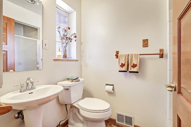 bathroom with walk in shower, tile patterned flooring, and toilet