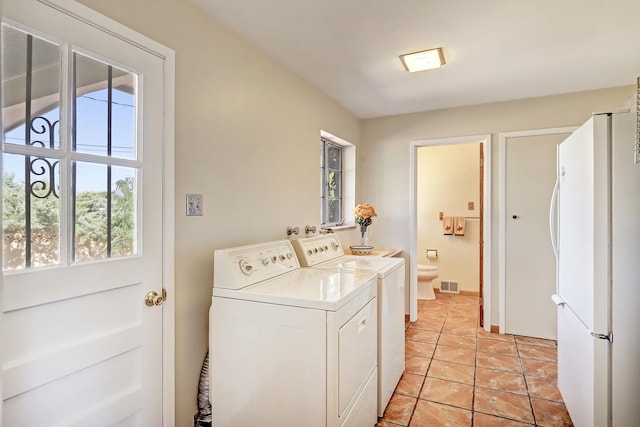 washroom with separate washer and dryer, light tile patterned floors, and a wealth of natural light