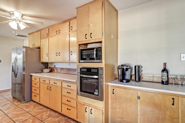 kitchen featuring stainless steel appliances, ceiling fan, light brown cabinets, and light tile patterned floors