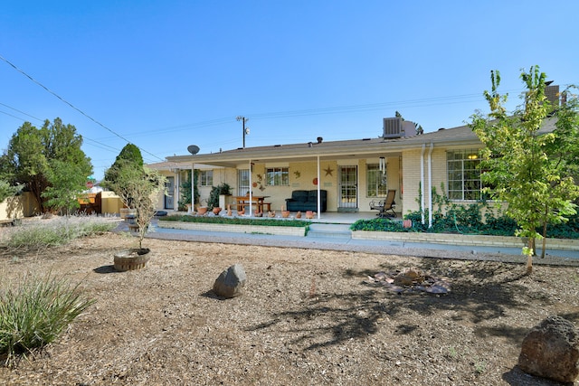 rear view of property featuring central air condition unit and covered porch