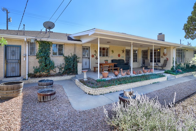 view of front of home featuring an outdoor living space with a fire pit and a patio area