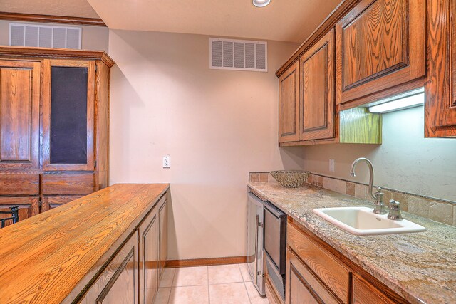 kitchen with wooden counters, sink, and light tile patterned floors