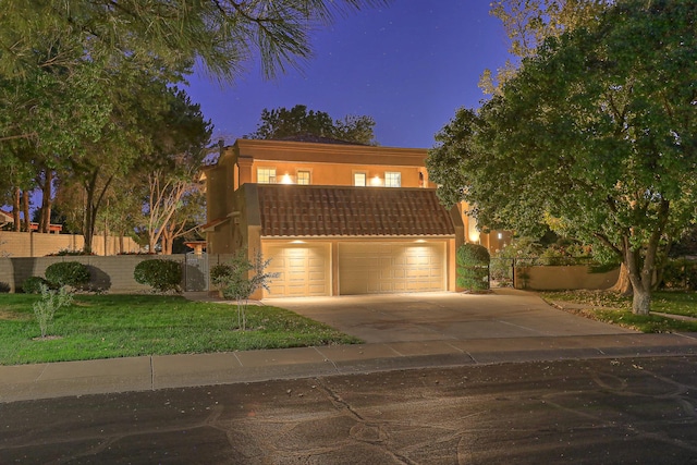 view of front of home with a garage and a lawn