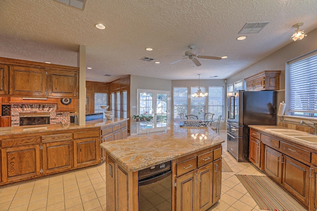 kitchen featuring a kitchen island, refrigerator, sink, decorative light fixtures, and a textured ceiling