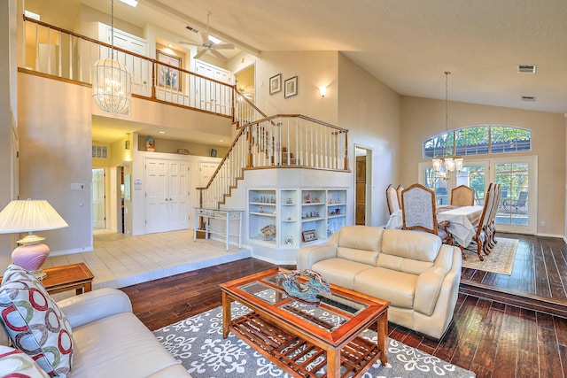 living room featuring ceiling fan with notable chandelier, hardwood / wood-style flooring, and high vaulted ceiling