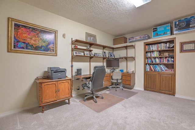 carpeted home office featuring a textured ceiling