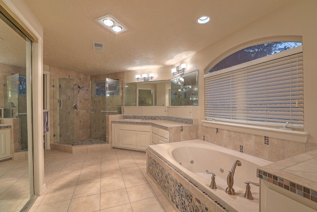 bathroom featuring tile patterned flooring, separate shower and tub, vanity, and a textured ceiling