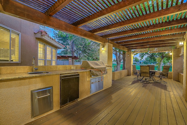 deck featuring an outdoor kitchen, a pergola, sink, and grilling area