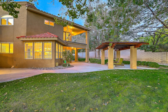 rear view of house with a patio area, a pergola, a balcony, and a lawn