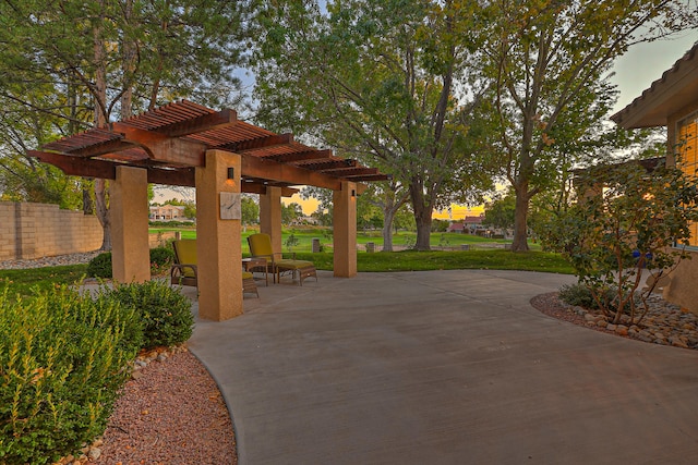 patio terrace at dusk with a lawn and a pergola