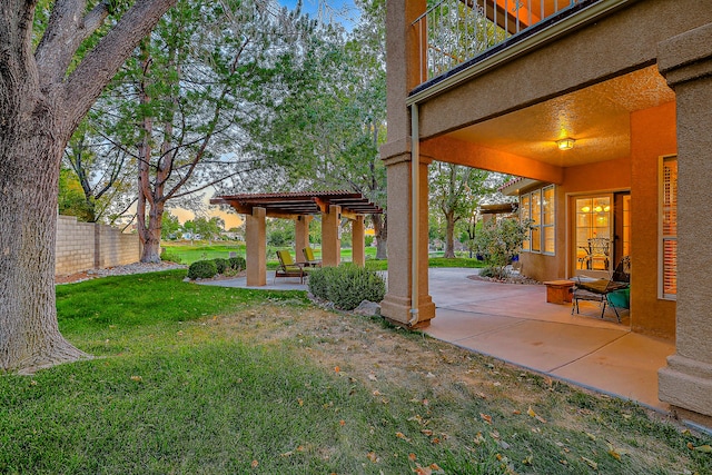 yard at dusk featuring a patio