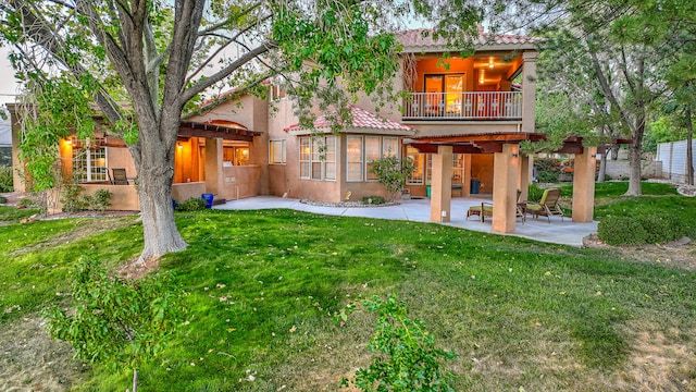 back of house with a patio, a balcony, and a lawn