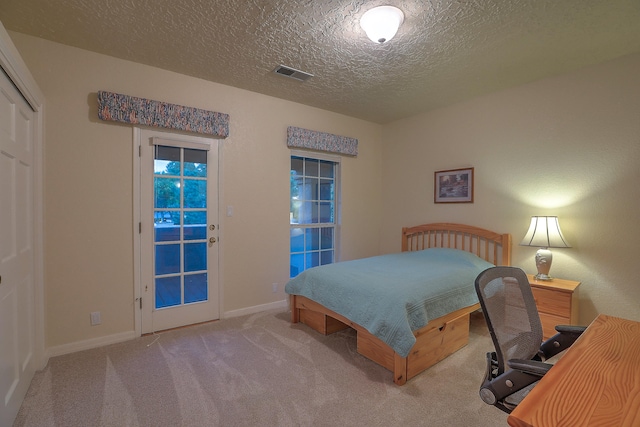 bedroom with light carpet, a textured ceiling, and access to exterior