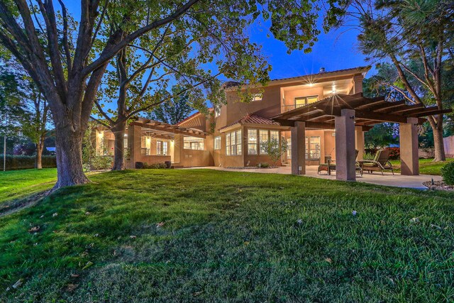 rear view of house featuring a yard, a pergola, and a patio