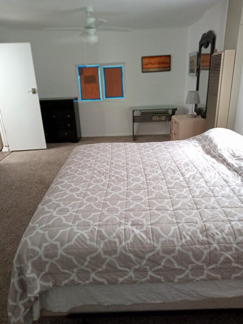 bedroom with ceiling fan and light carpet